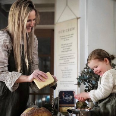An adult and a child stand at a kitchen counter, smiling while preparing food together. - Link to Instagram post